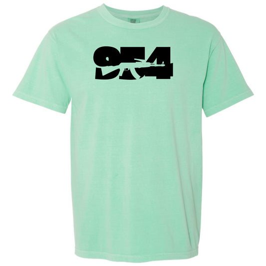An island reef green short-sleeve crewneck t-shirt featuring a bold black graphic print of the numbers '954' Fort Lauderdale area code on the chest with a silhouette of an AK-47 rifle, displayed against a solid white background.